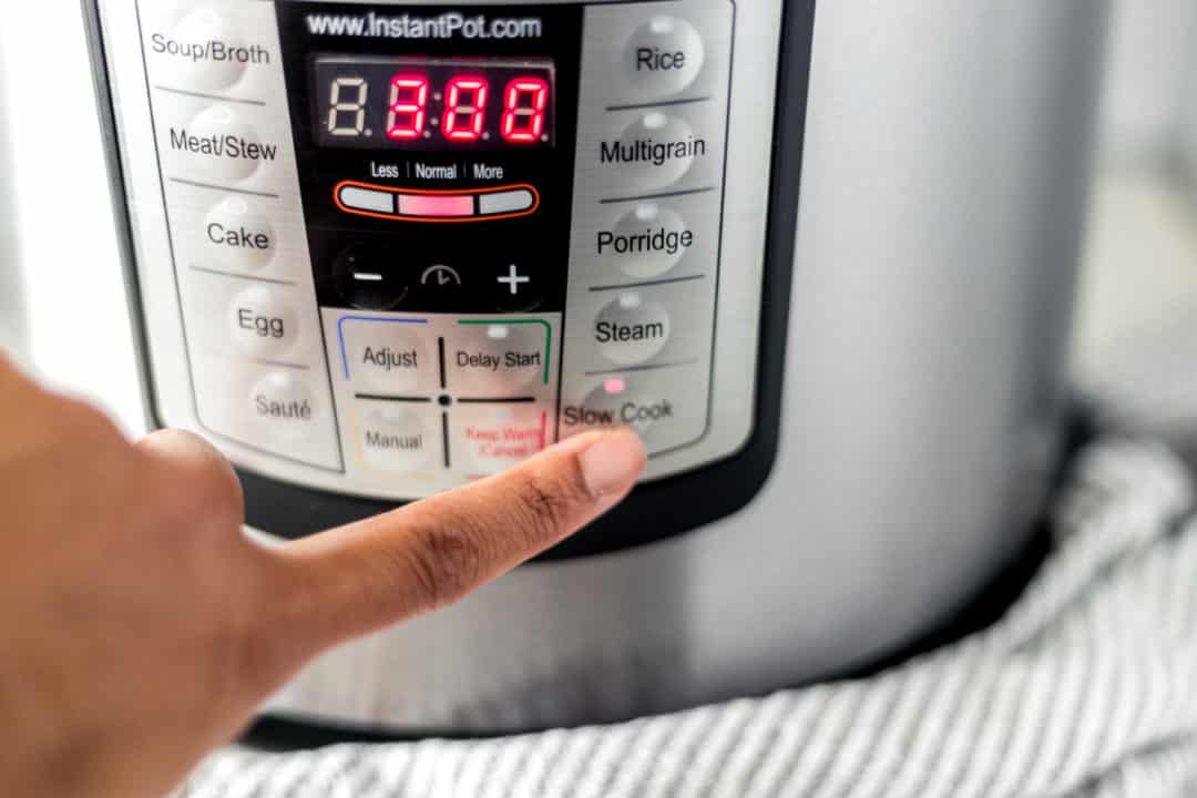 finger touching slow cook setting on instant pot 