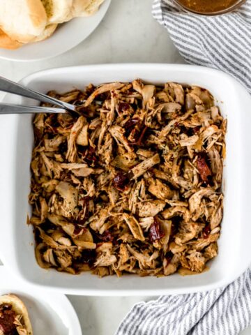 pulled pork in square white baking dish with forks in it