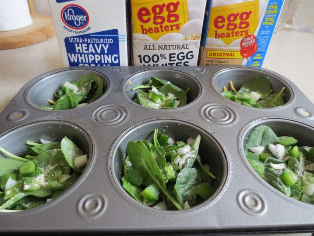 chopped vegetables added to the bottom of a muffin pan 