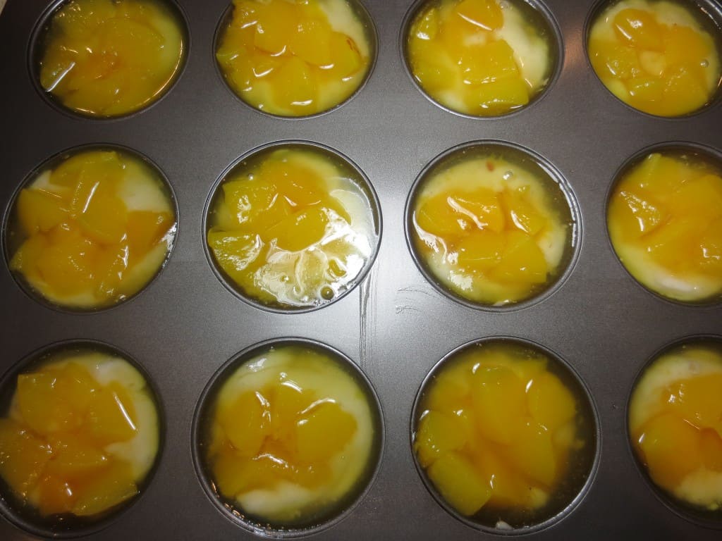  overhead view of mini peach cobbler in muffin pan before adding sugar and spices