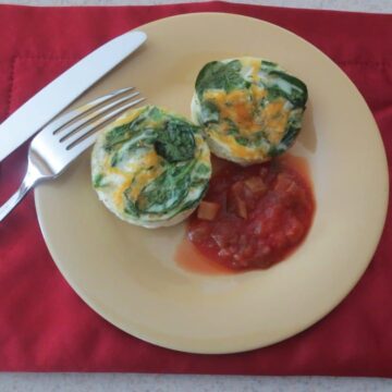 finished eggs on yellow plate with salsa, knife, and fork