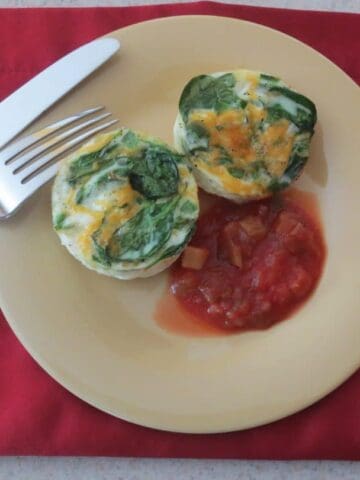 finished eggs on yellow plate with salsa, knife, and fork