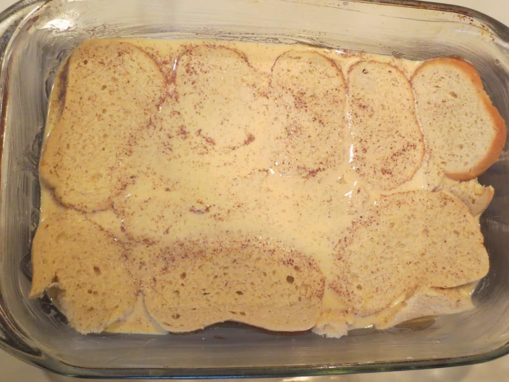 egg mixture poured on top of bread in baking dish 
