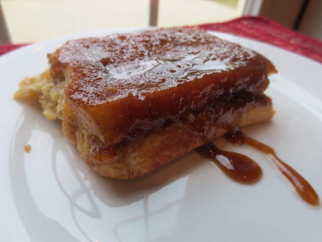 close up side view of finished french toast on white plate 