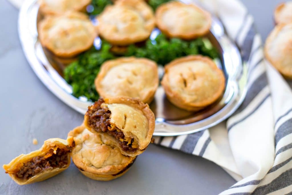 close up side view of pies on silver platter with cloth napkin