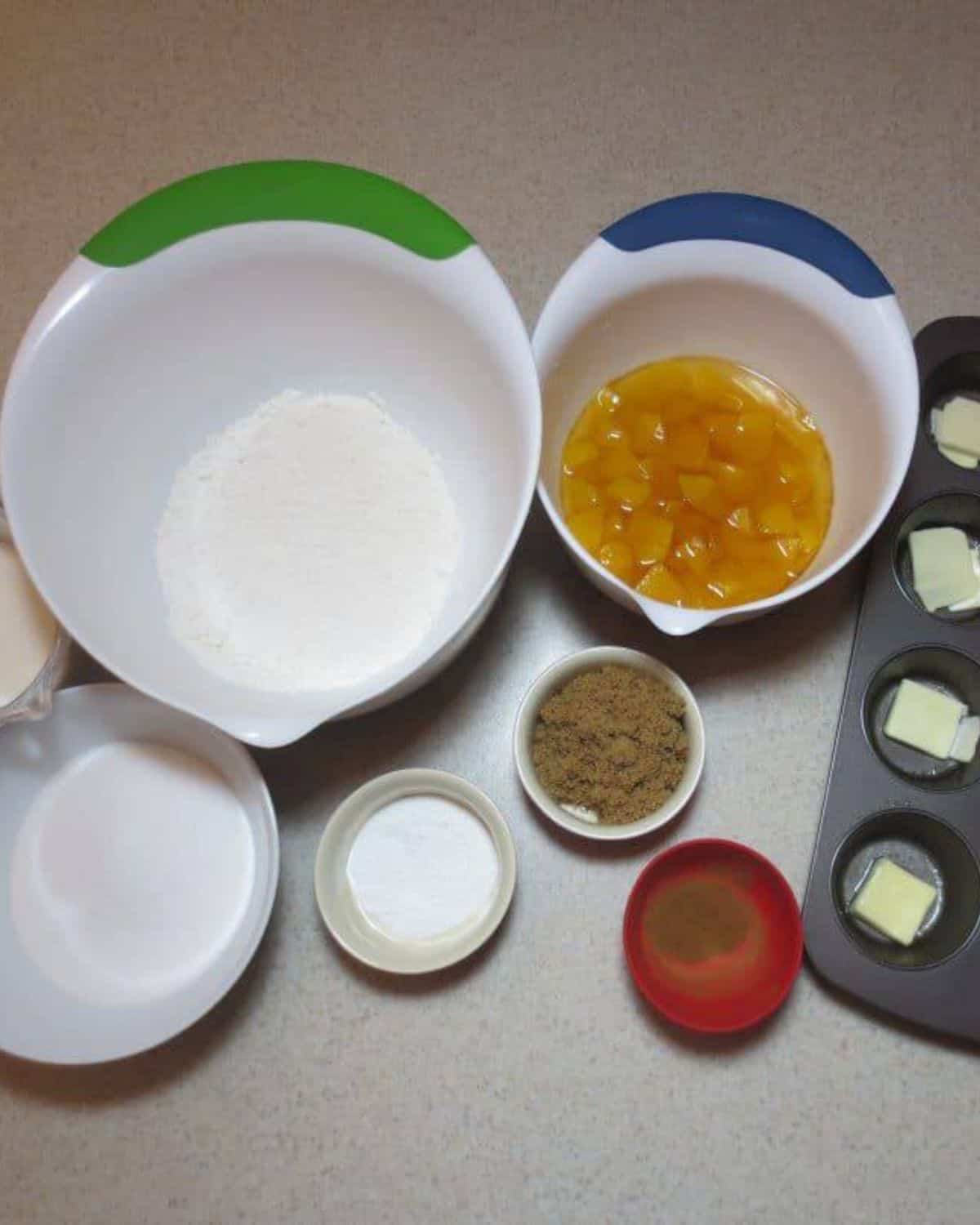 Ingredients needed to make cobbler in separate bowls. 