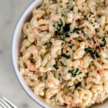 macaroni salad in large white serving bowl with fork