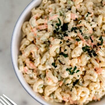 macaroni salad in large white serving bowl with fork