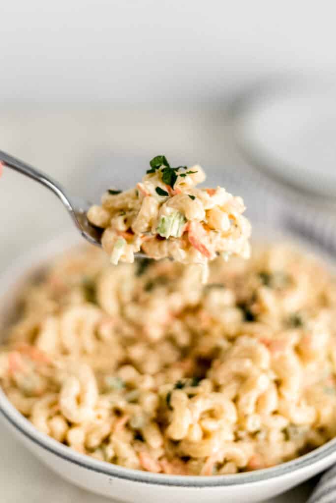 hand holding fork with macaroni salad on it