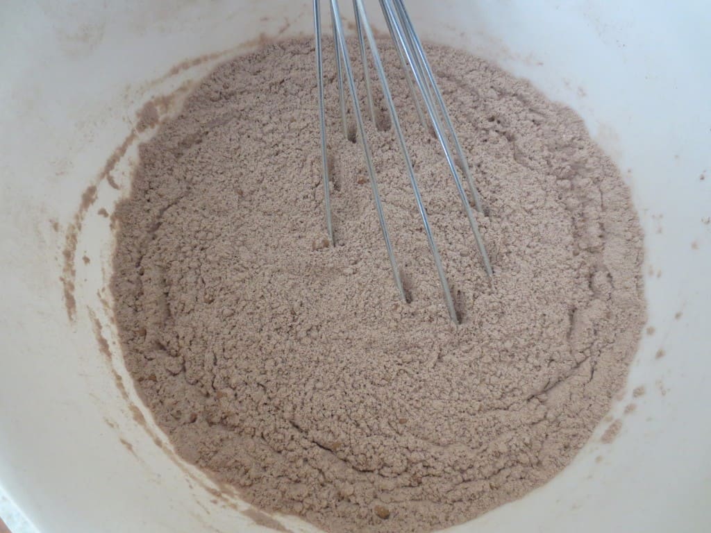 dry brownie ingredients in mixing bowl with whisk 