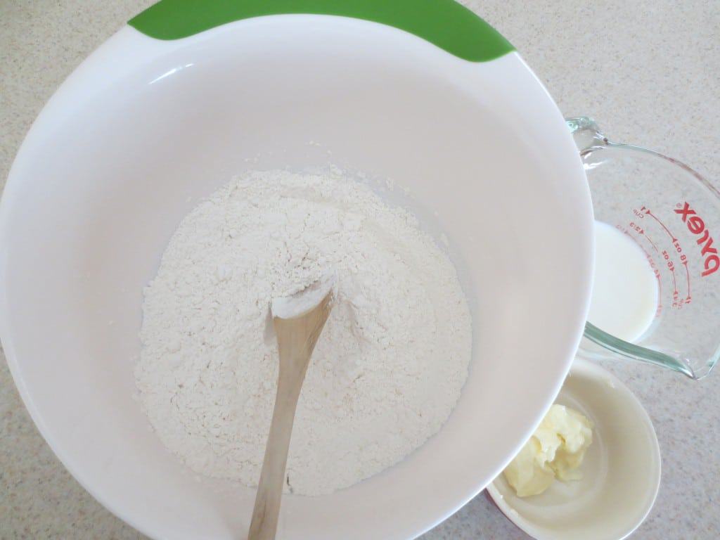 dry ingredients for mayonnaise drop biscuits in large white mixing bowl with wooden spoon