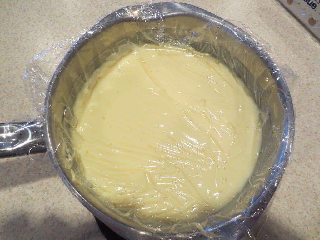 pudding in saucepan topped with plastic wrap