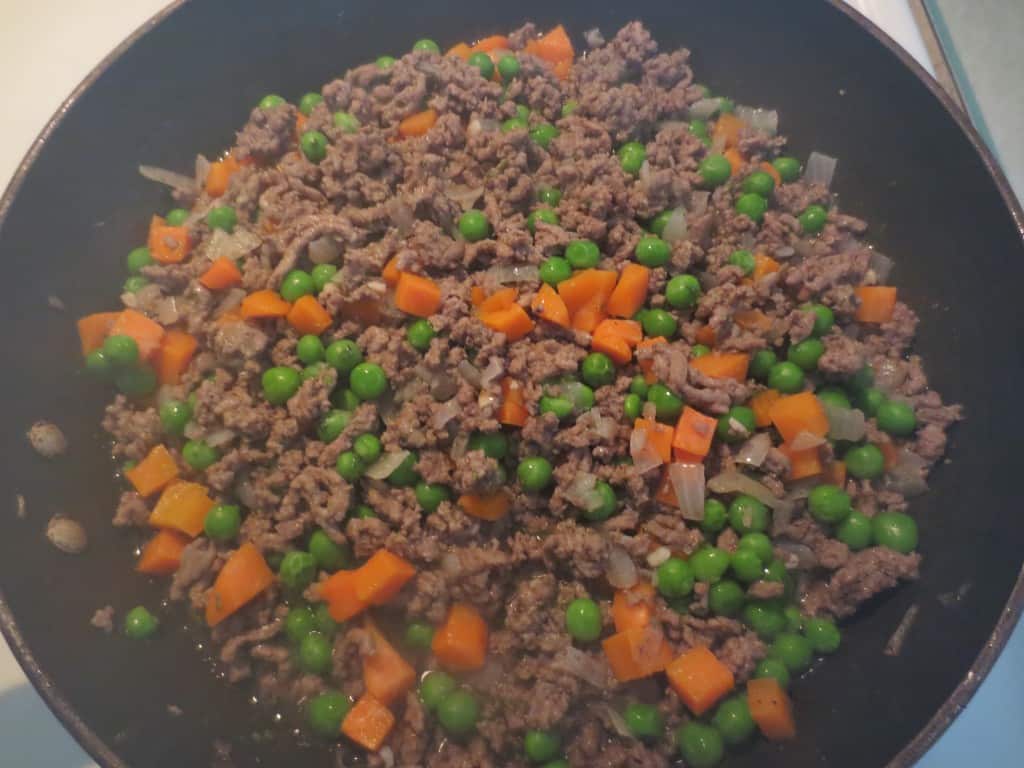 peas and carrots added to beef in skillet