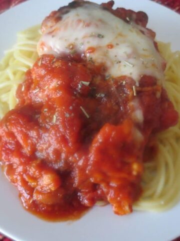 white plate of finished chicken parm with spaghetti