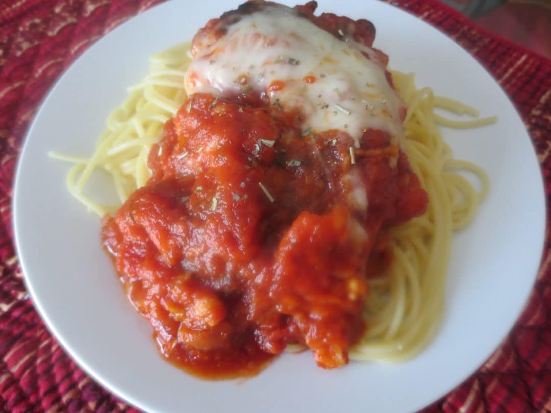 white plate of finished chicken parm with spaghetti