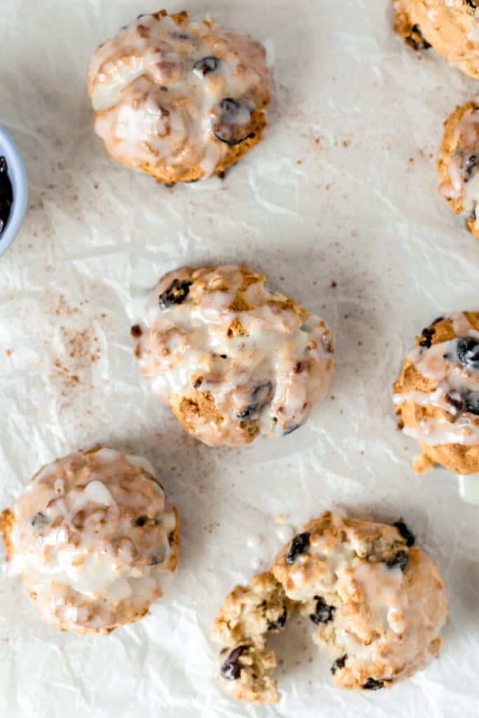 baked and glazed cherry oat scones on parchment paper 