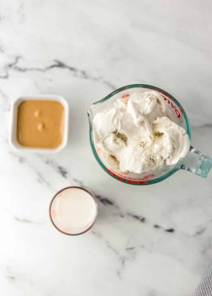 ingredients needed to make milkshake on marble surface. 