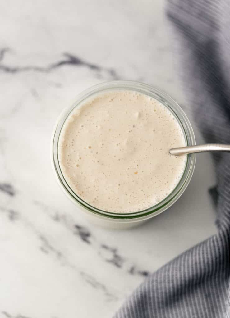 top of peanut butter shake in glass with metal straw