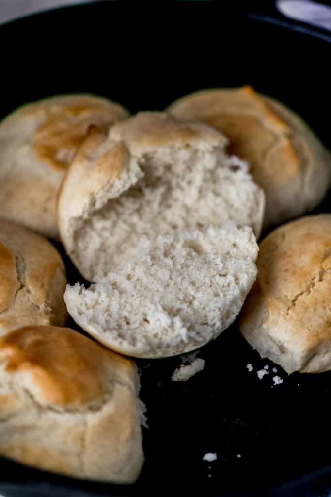 biscuit cut in half in cast iron skillet with jam on it