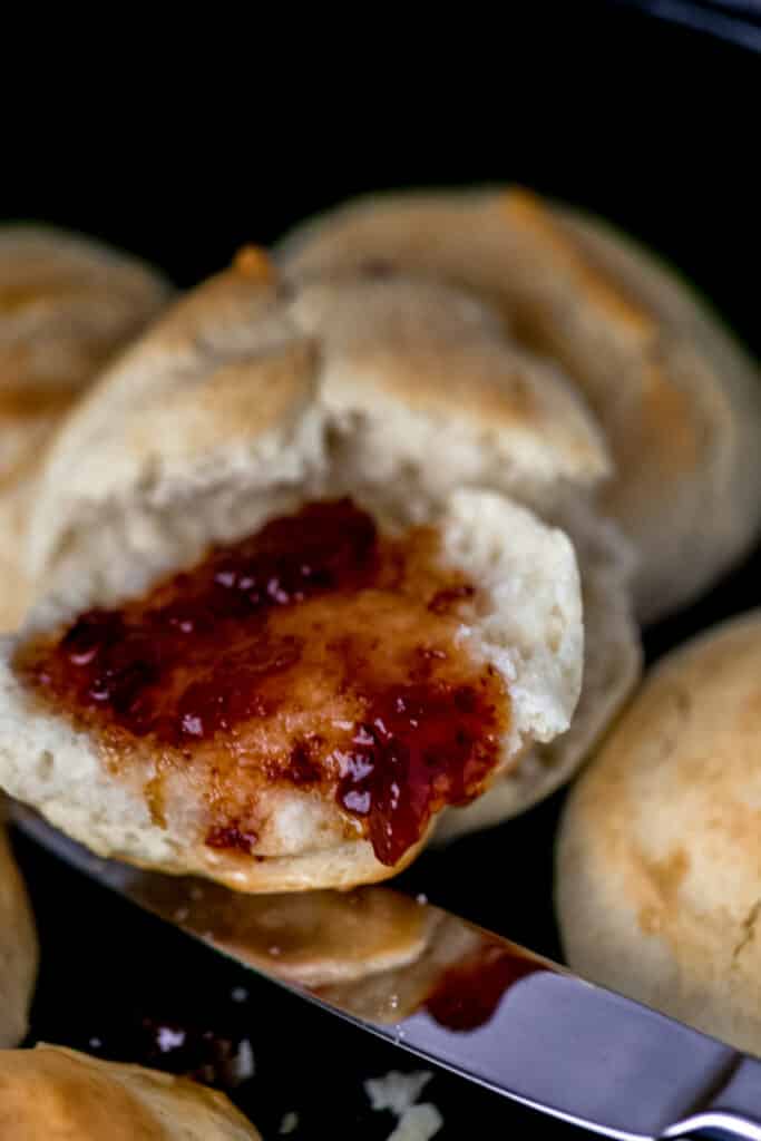 biscuit cut in half with jam spread on it