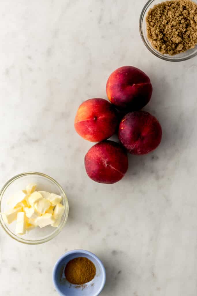 ingredients for brown sugar peaches in small bowls with 4 fresh peaches