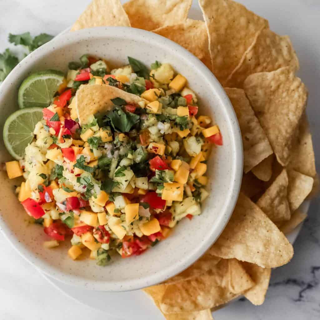 overhead view of bowl of salsa on plate with chips