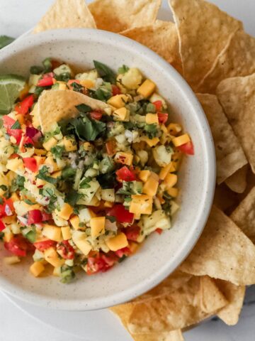 overhead view of bowl of salsa on plate with chips