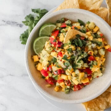 overhead view of bowl of salsa on plate with chips