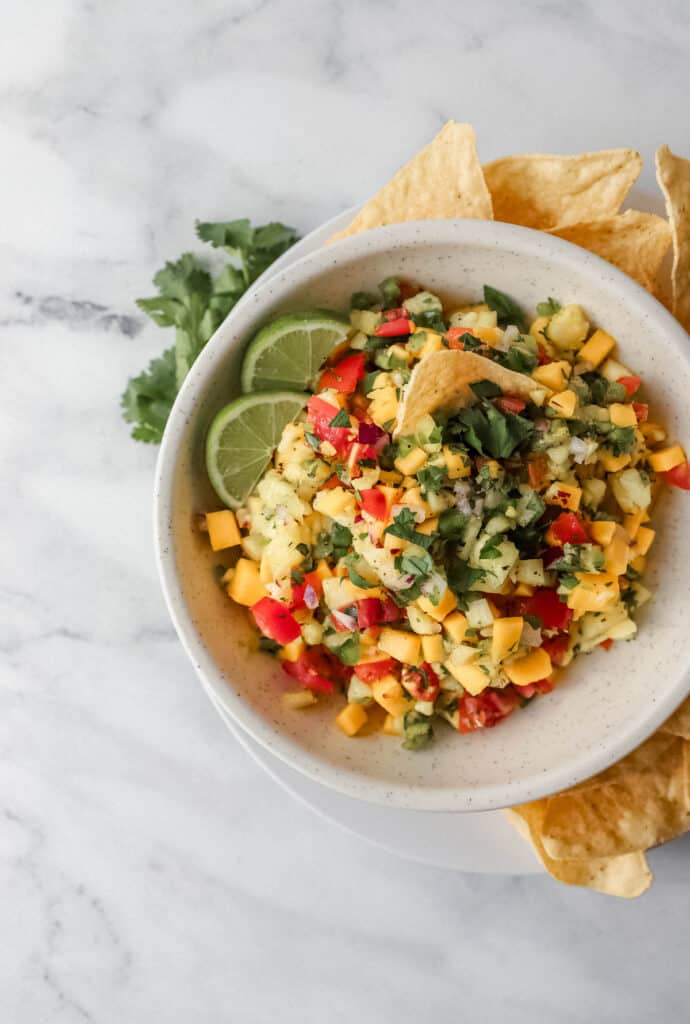 overhead view of bowl of salsa on plate with chips