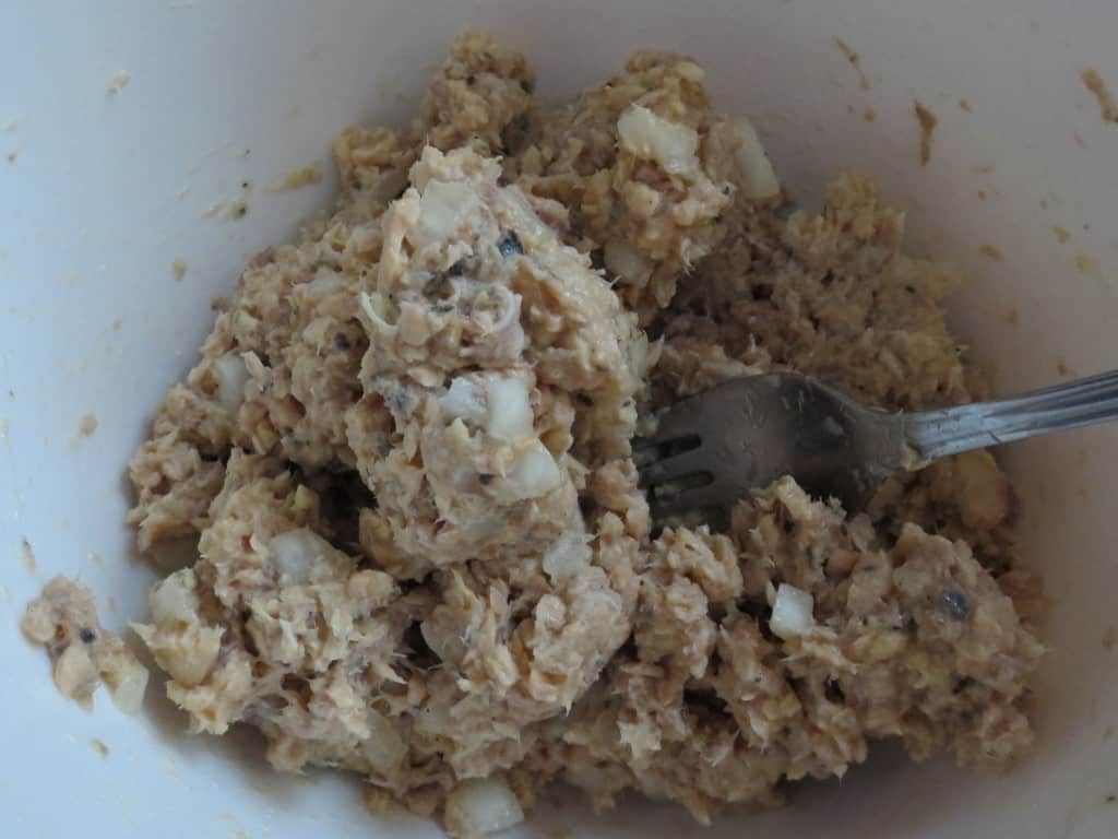 salmon patty mixture in a white mixing bowl with fork 