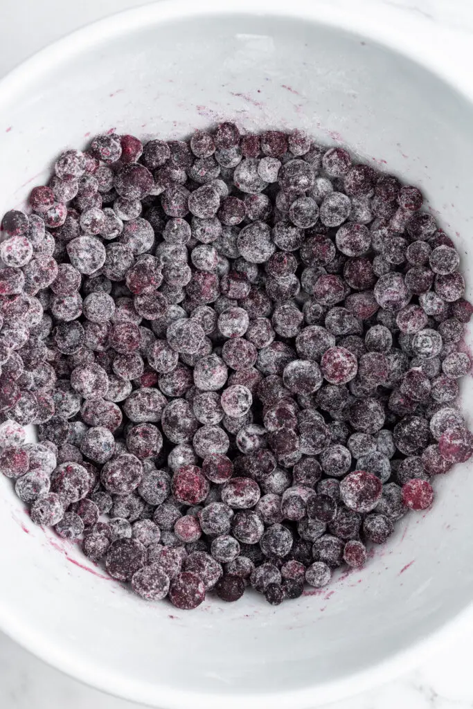 blueberries and flour combined in mixing bowl 
