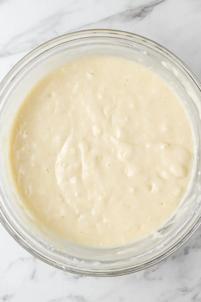 wet and dry ingredients combined in glass mixing bowl for lemon bread 