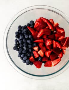 strawberries and blueberries in a glass bowl