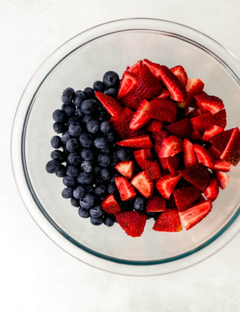 strawberries and blueberries in a glass bowl 