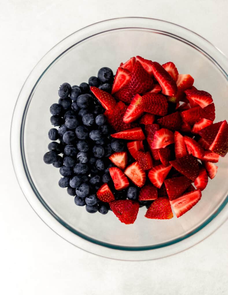strawberries and blueberries in a glass bowl