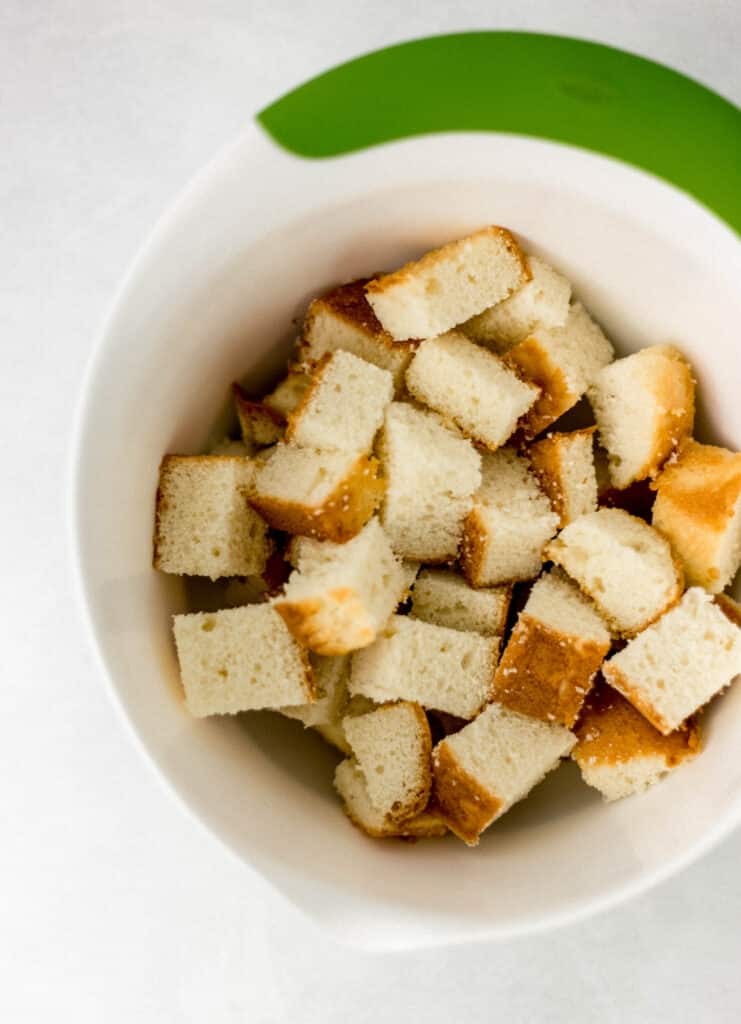 butter pound cake cut up in white medium mixing bowl 