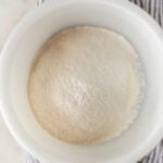 self rising flour in a white bowl over a napkin