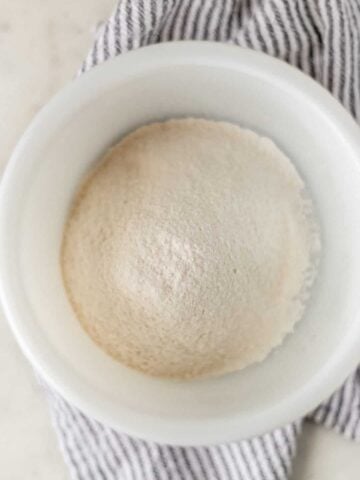 self rising flour in a white bowl over a napkin