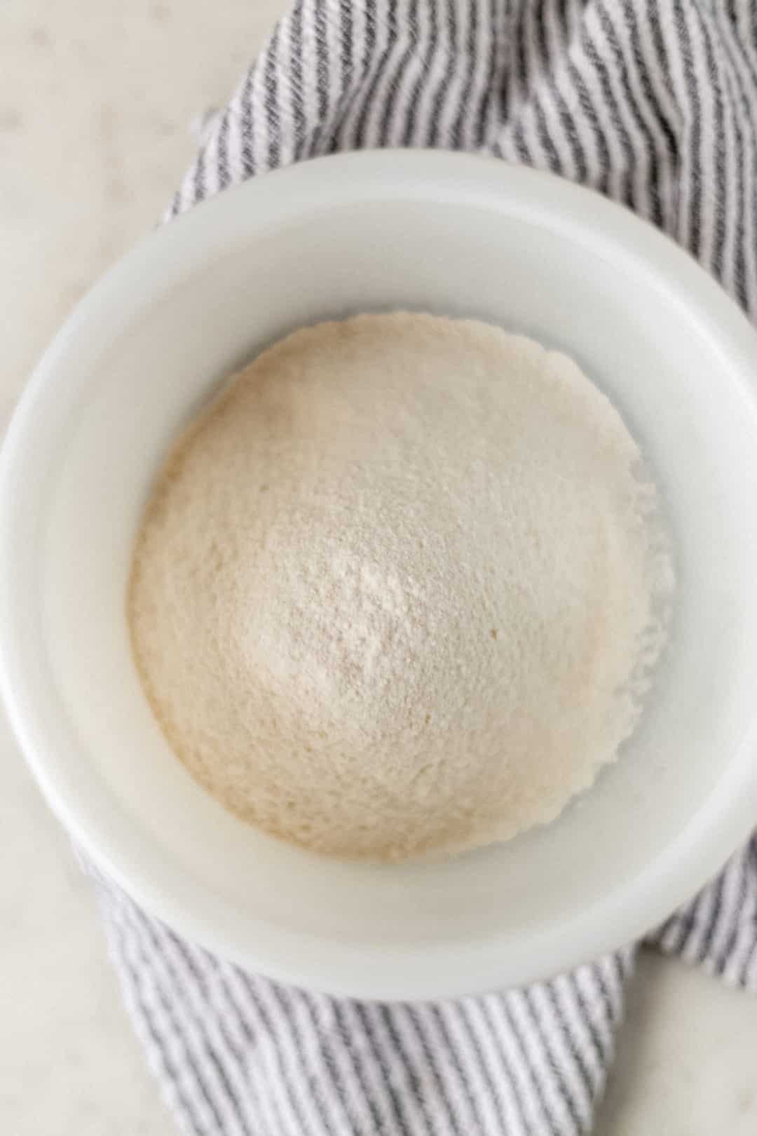 self rising flour in a white bowl over a napkin