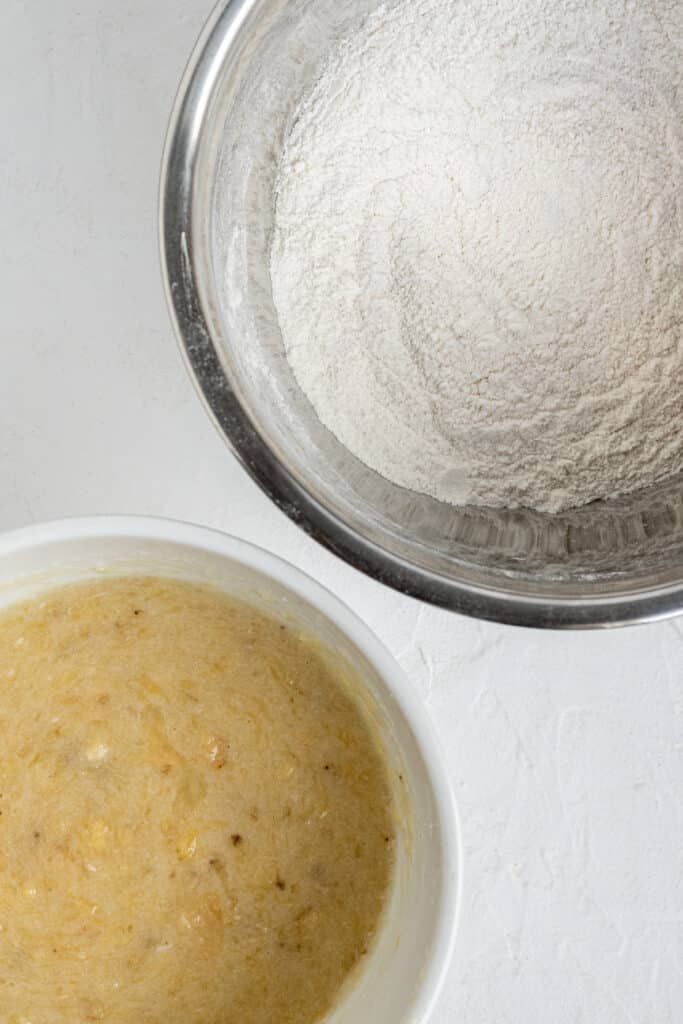 two separate mixing bowls with ingredients to make muffins combined, wet and dry. 