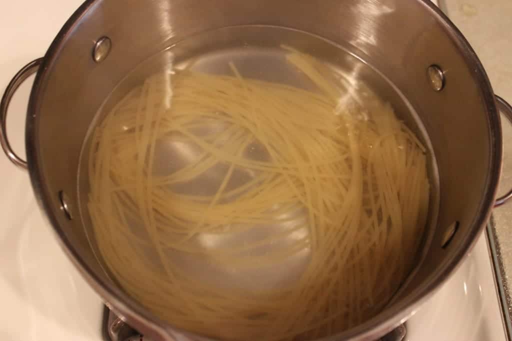 spaghetti in water in a pot on the stovetop