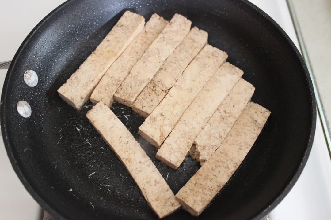 tofu cut into strips in skillet 
