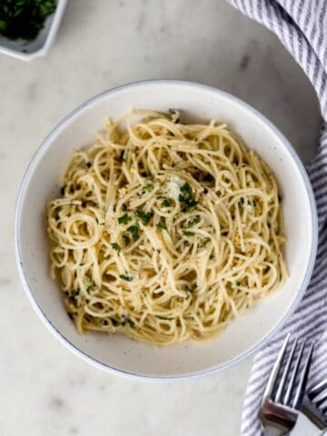 overhead view pantry pasta in white bowl with napkin and forks