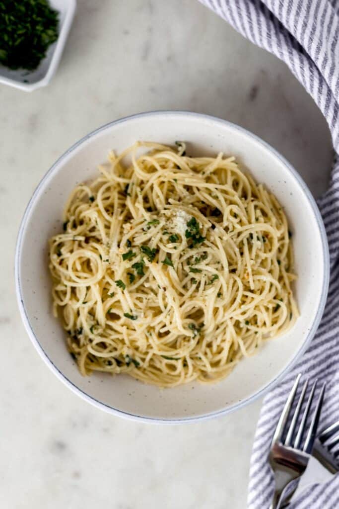 overhead view pantry pasta in white bowl with napkin and forks 