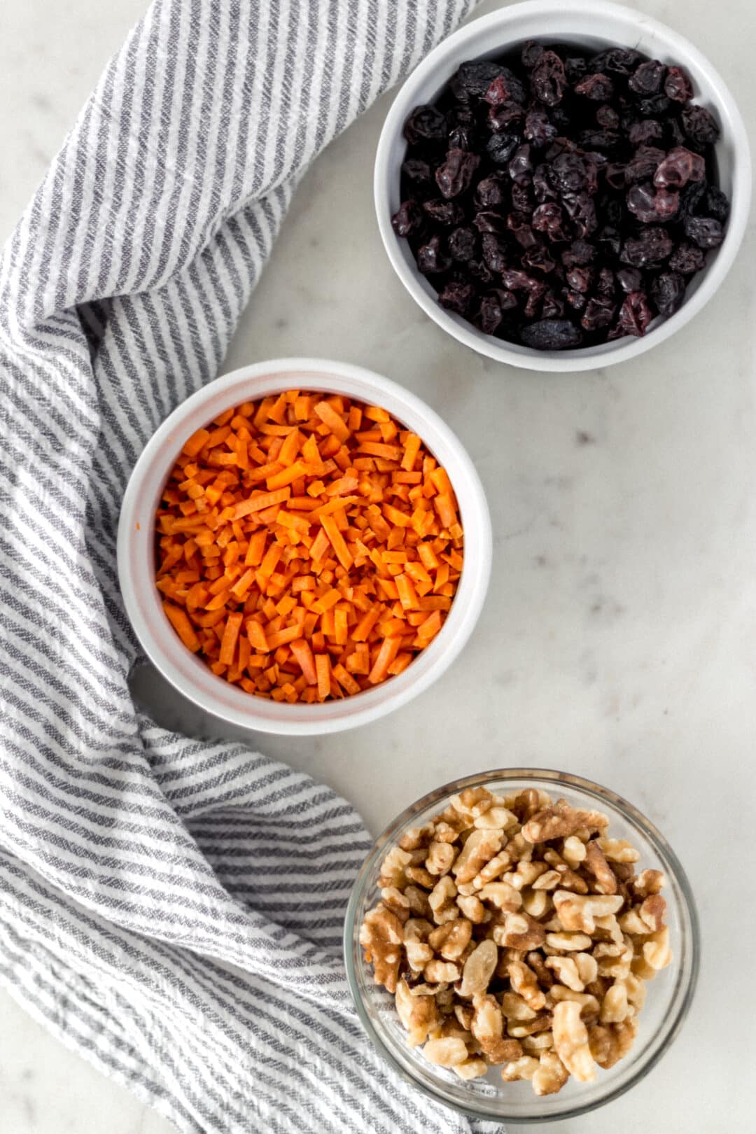 small bowls with shredded carrot, walnuts, and raisins