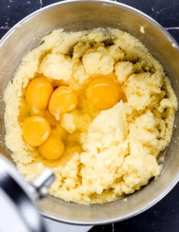 Eggs added to butter and sugar in stand mixer bowl.