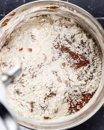 Flour mixture added to pound cake mixture in stand mixer bowl.