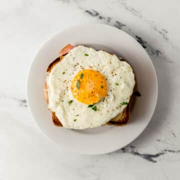 finished croque madame on small white plate