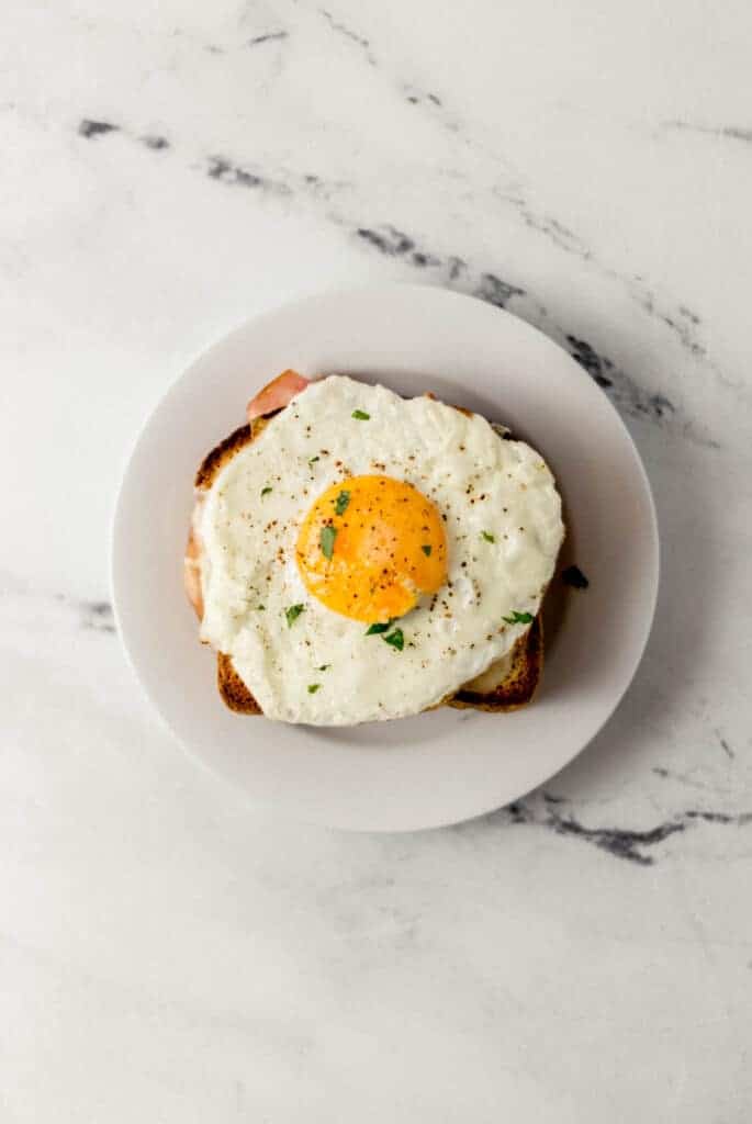 finished croque madame on small white plate