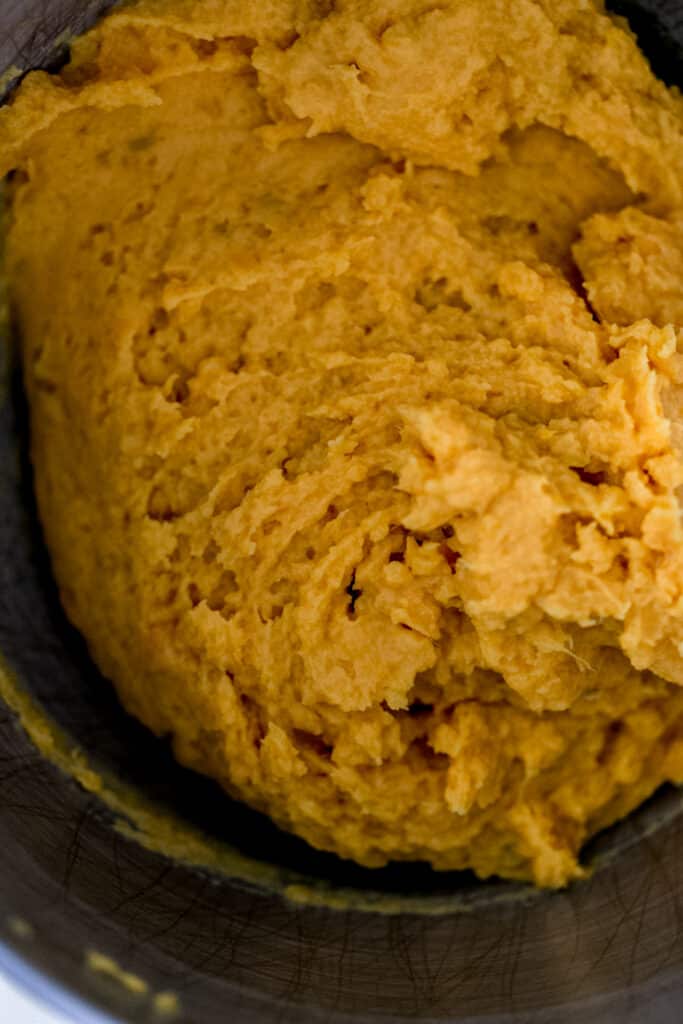 overhead view sweet potato and butter combined in mixer bowl